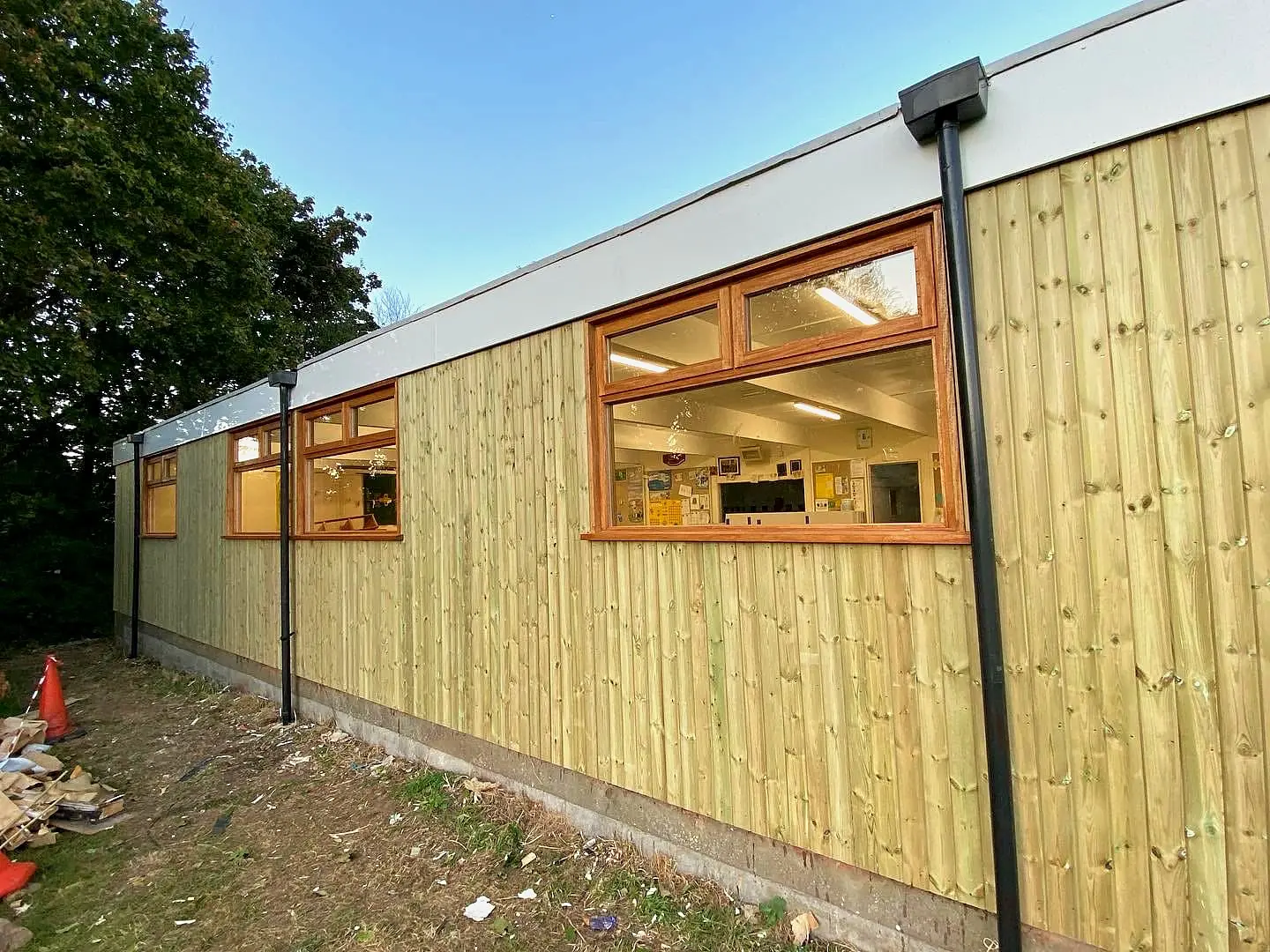 Single-storey commercial building clad in vertical timber with timber-framed windows