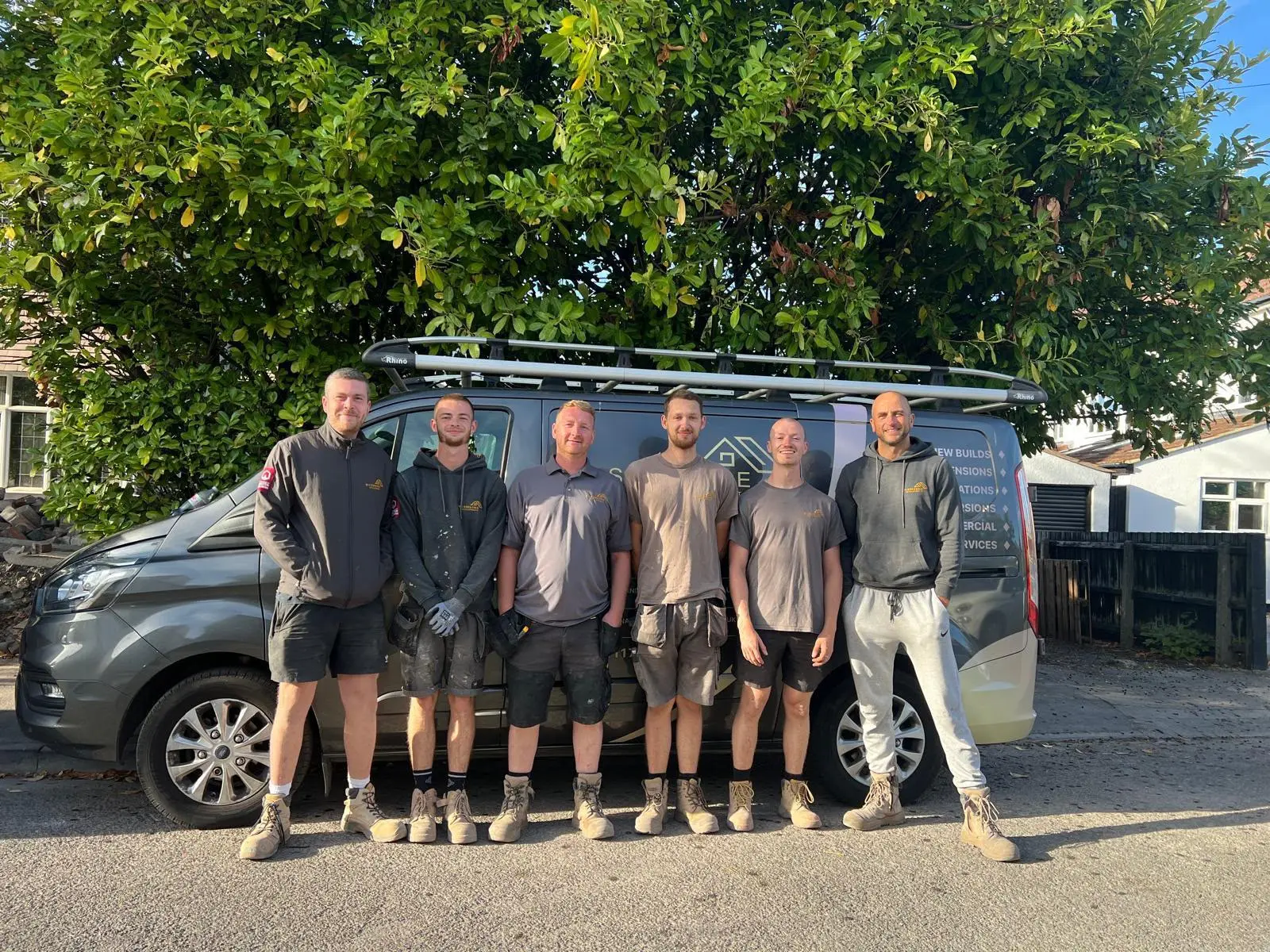 The Wilson & Cole team standing in front of their van